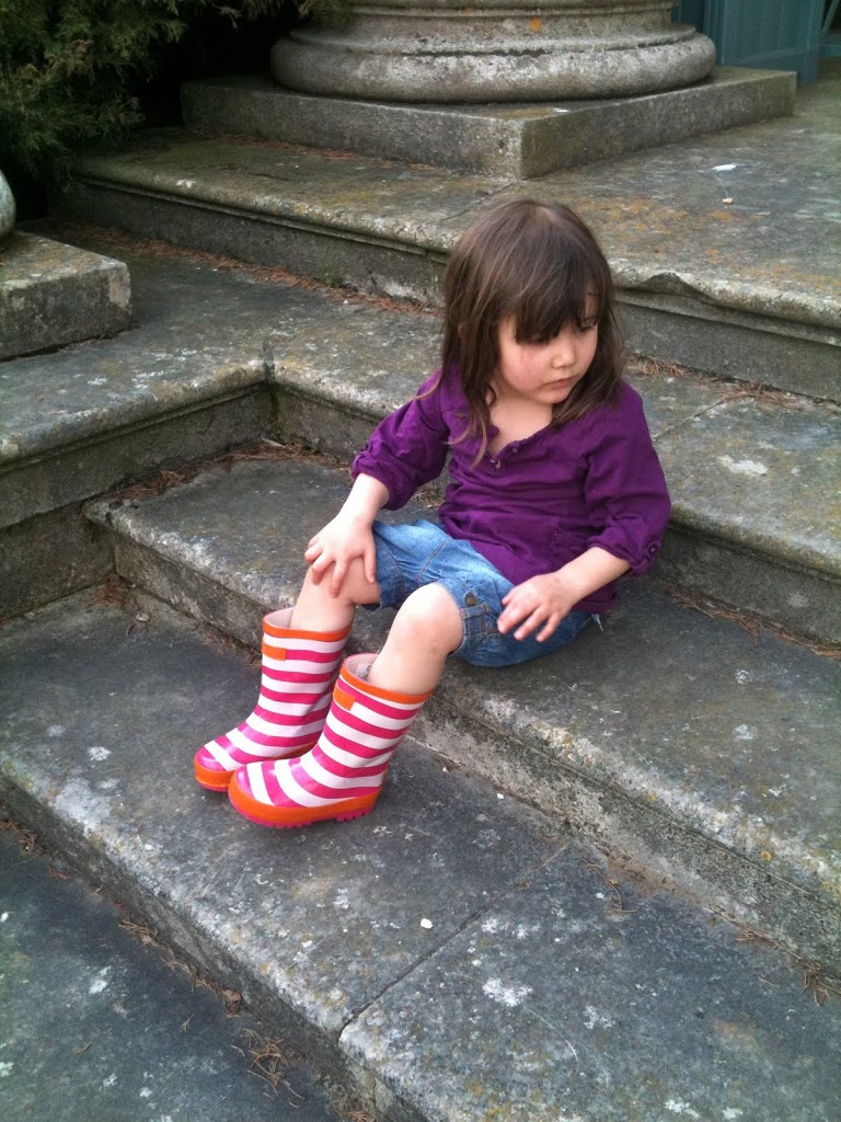 Big Sis sitting on steps in striped wellies