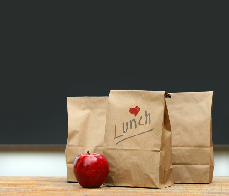 Lunch bags with apple on school desk