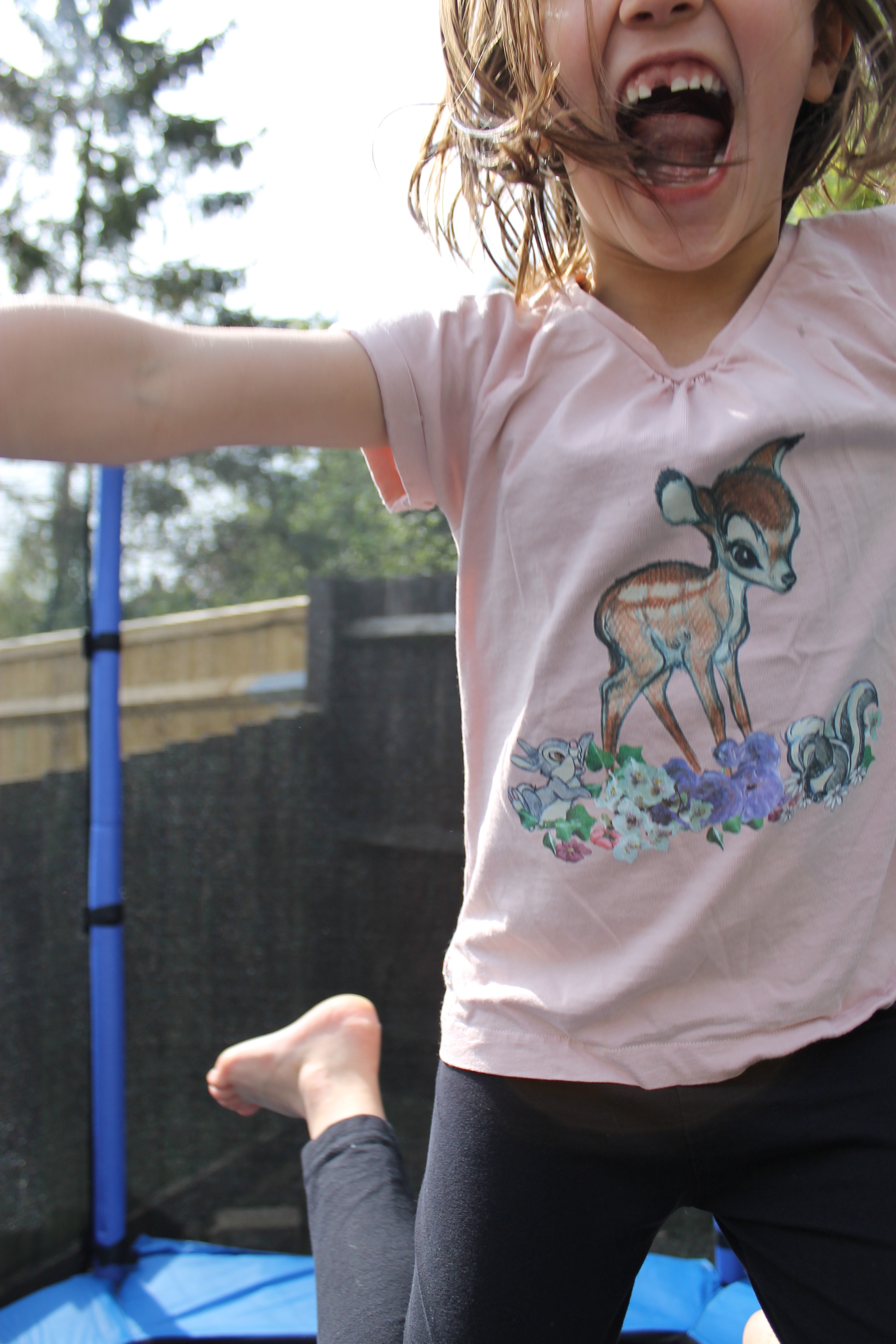 Big Sis bouncing towards camera kids' trampoline