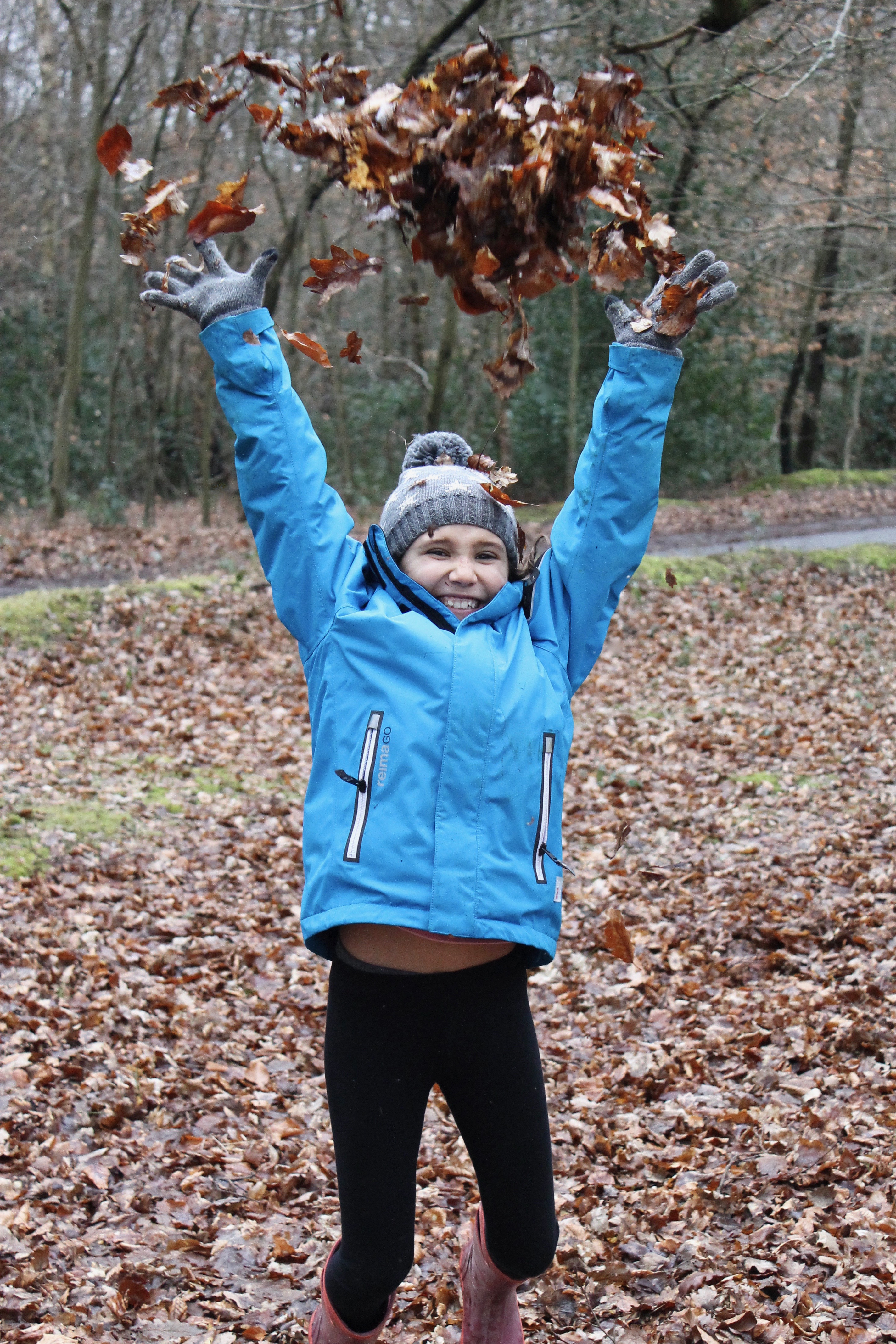 Reima kid's outdoor jacket throwing leaves