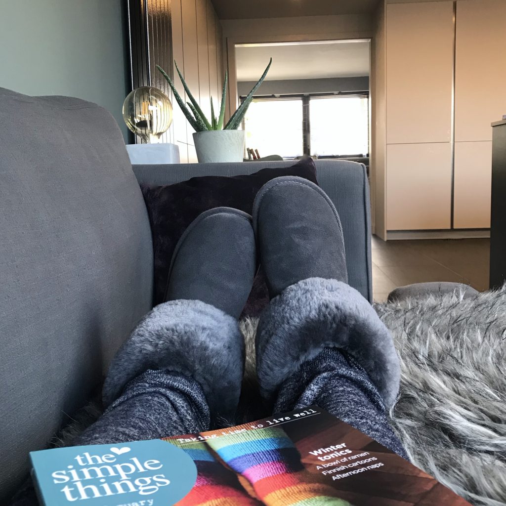 Lying on sofa wearing comfy sheepskin slippers