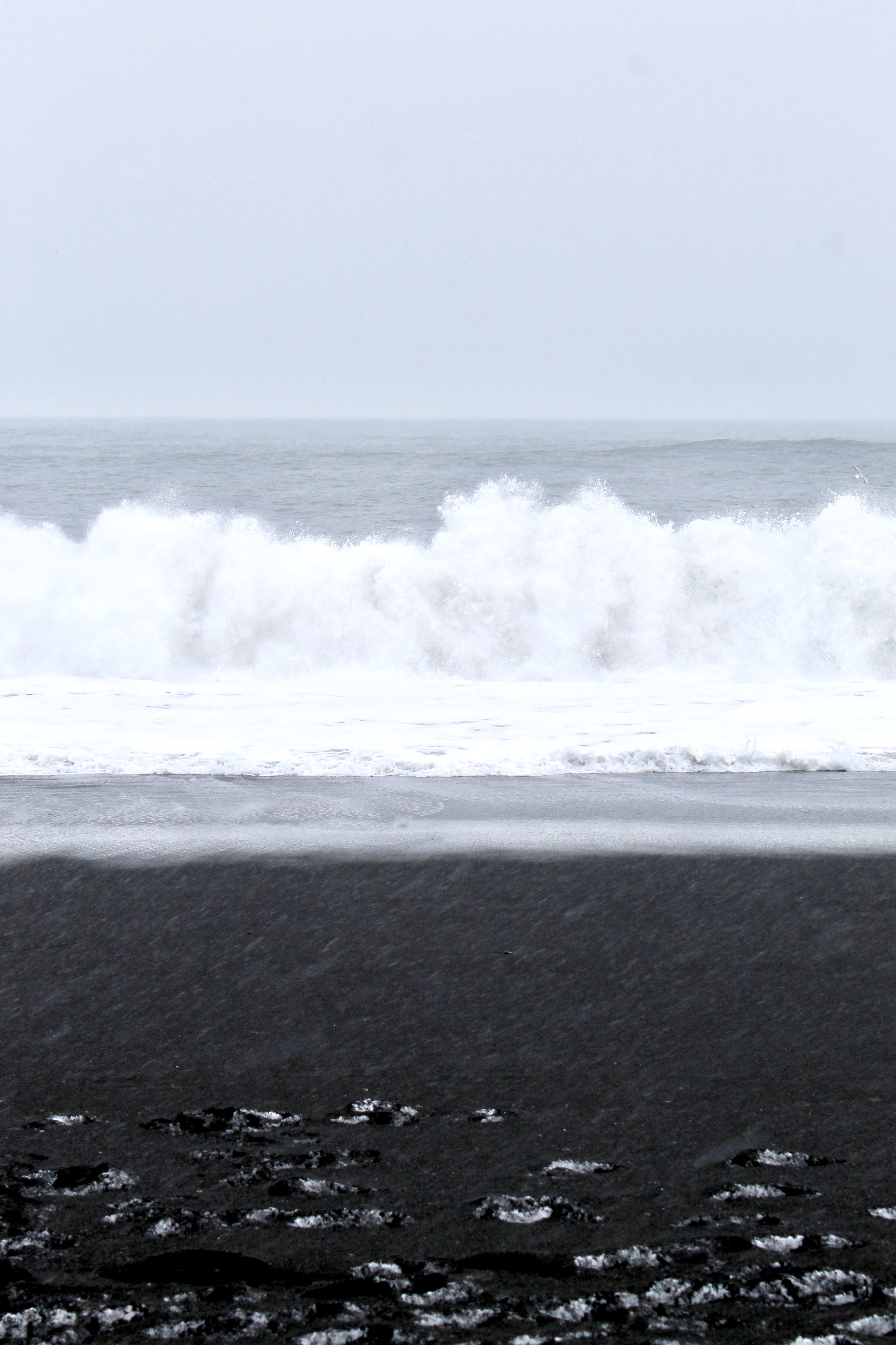 Solo travel to Iceland black sand beach waves crashing