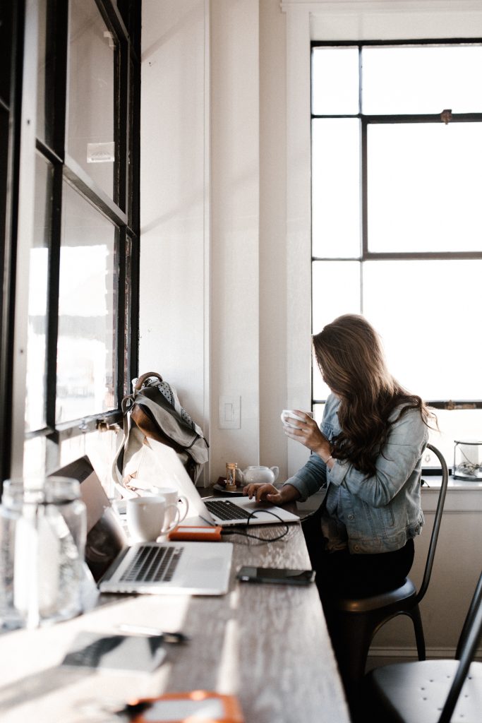 How to Work Successfully with a Blogger - holding shot of blogger working at cafe