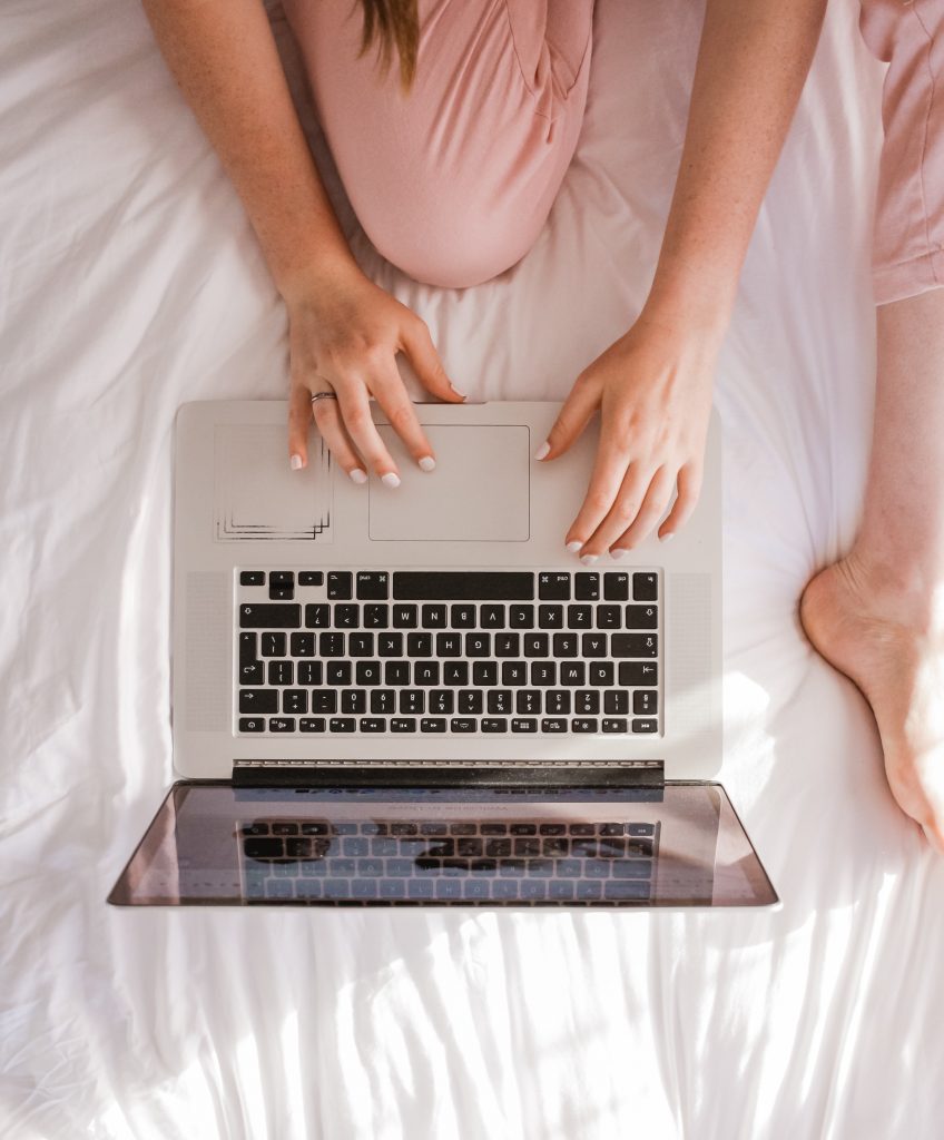 How to Work Successfully with a Blogger - blogger working on bed with open laptop